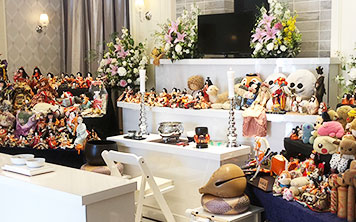 人形供養祭で葬儀祭壇に祀られた人形の前でお坊さんが読経している様子
